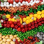 A stand with vegetables such as yellow pepper, beetroot, tomatoes, cucumber, pumpkin, carrots, radish, beetroot, garlic.